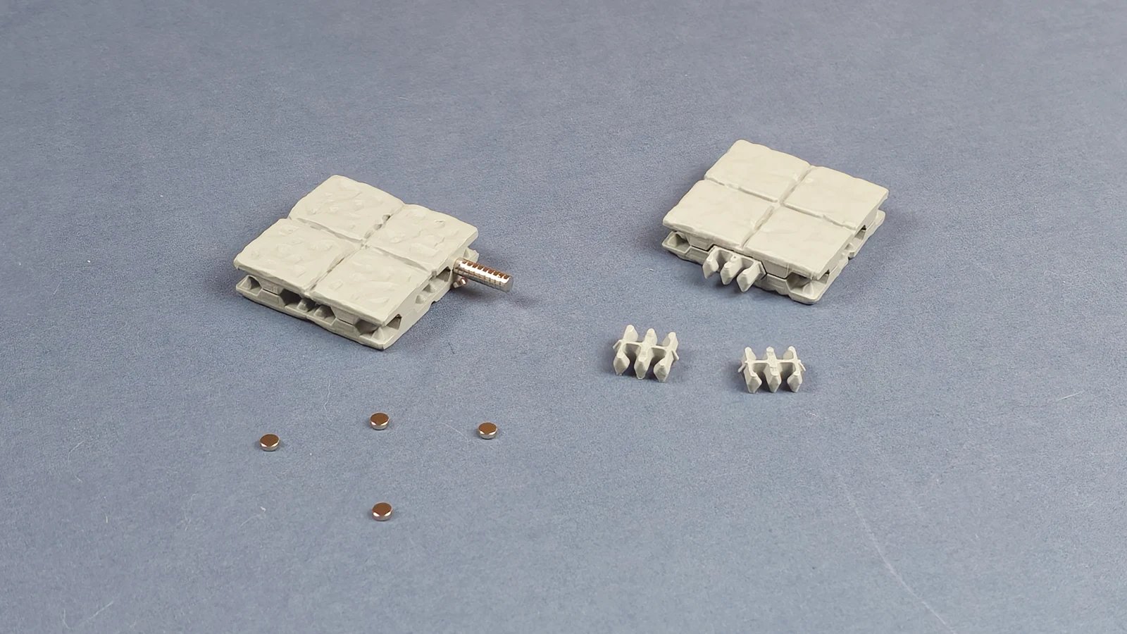 Floor pieces with loose magnets and clips arranged on a grey surface
